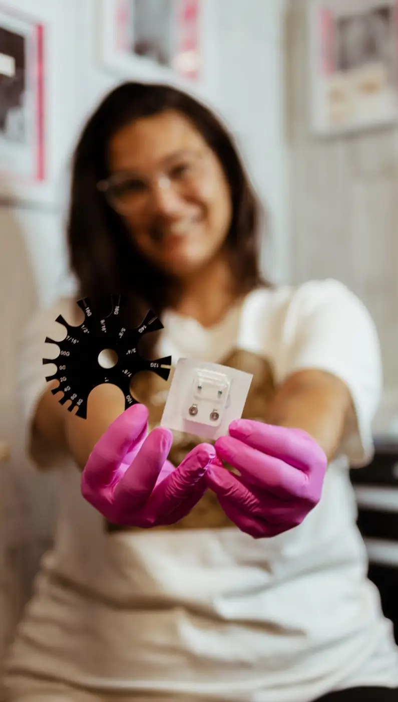 Kathryn présentant des bijoux stériles et une jauge de calibrage